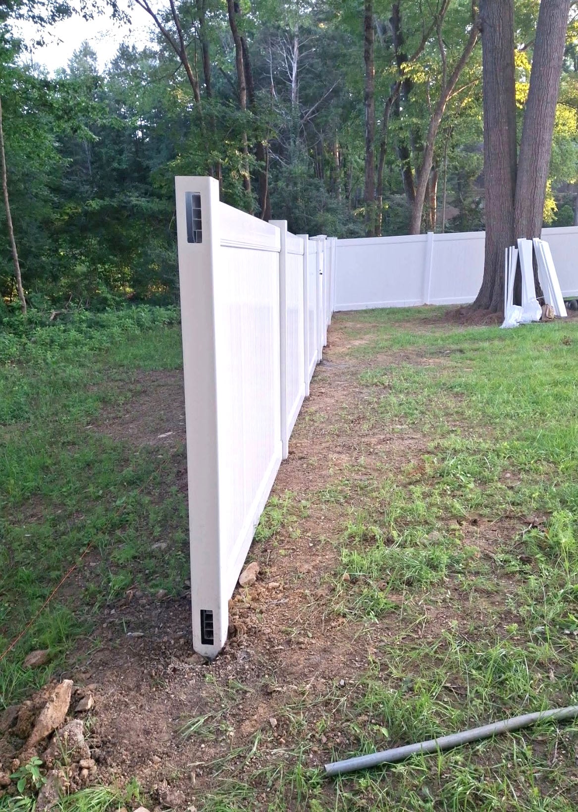 White vinyl privacy fence installed in a residential backyard